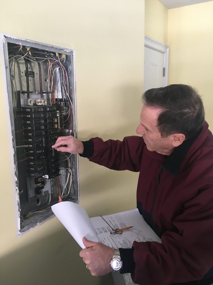 Total Home Inspection examining a circuit breaker in a client's home.